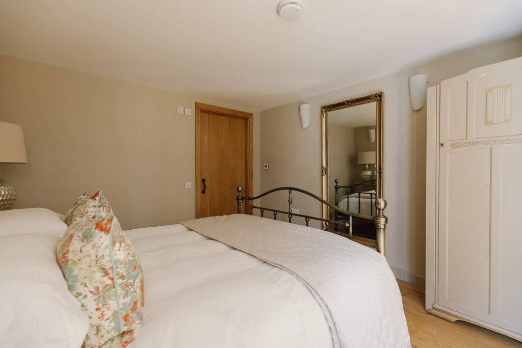 Large bed in a bedroom with two doors to other rooms