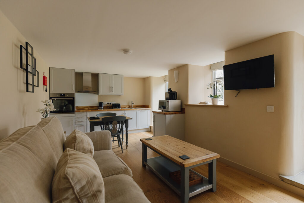 Open plan kitchen, kitchen table and lounge area with sofa coffee table and tv