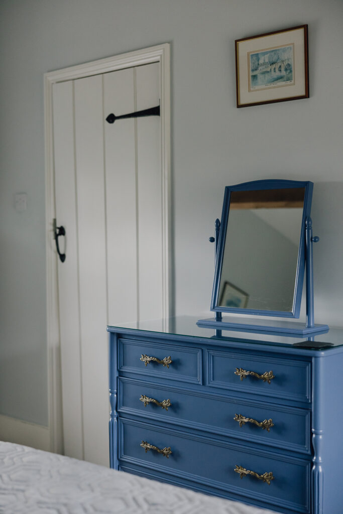 Navy blue chest of drawers with a door next to it