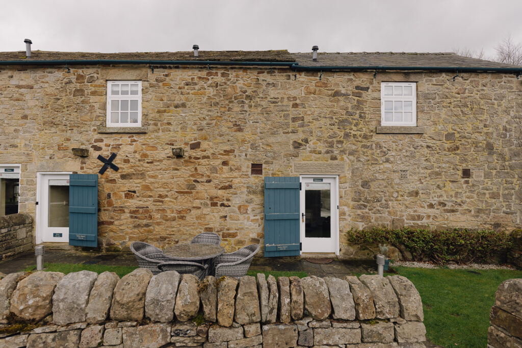 Rustic stone brick building with door and outside rattan furniture