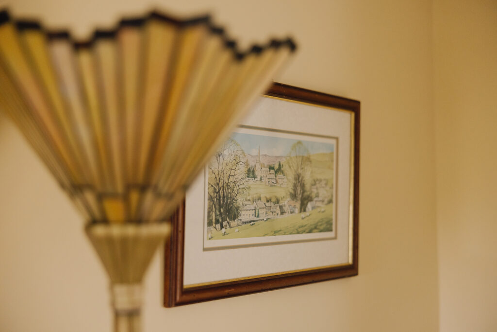 Painting on the wall with lampshade next to it