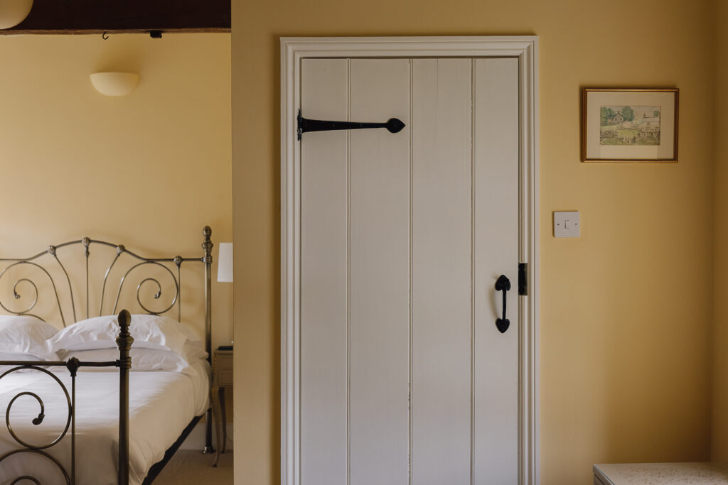 Traditional door with bed to the left.