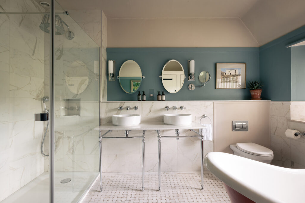 Bathroom at moorview bathroom with his and hers sinks, roll top bath and walk in shower