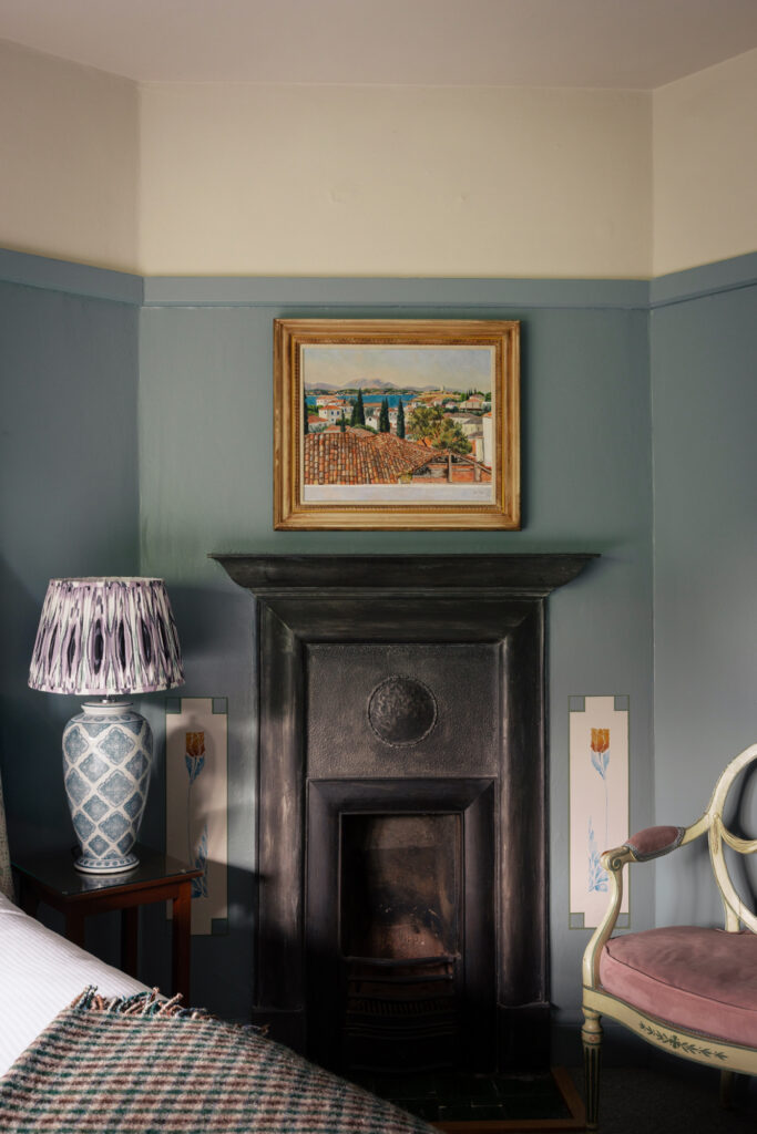Traditional fireplace by the side of the bed