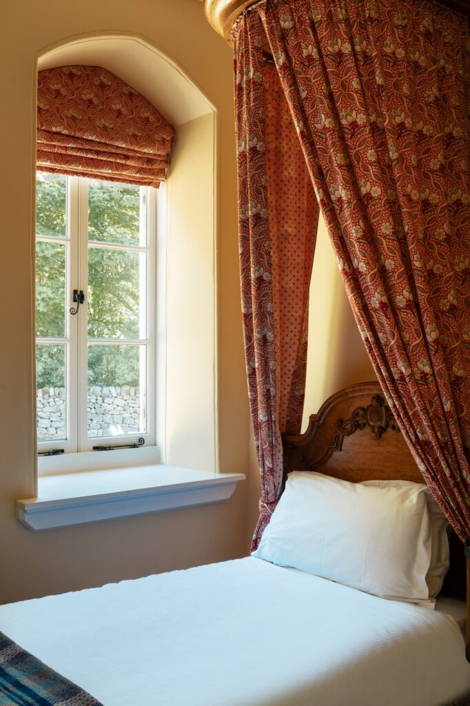 close up of a single bed with drapes
