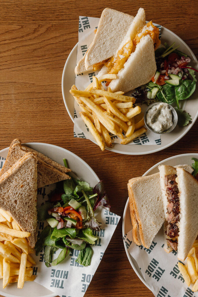 A selection of sandwiches, chips and salad.