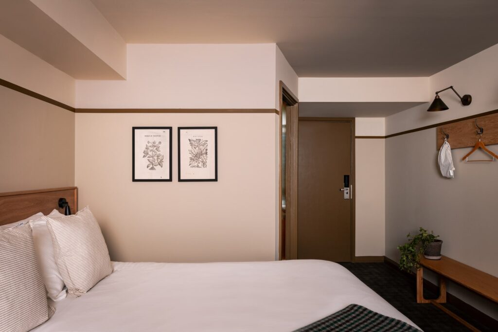 Double bed with two pieces of art on the wall
