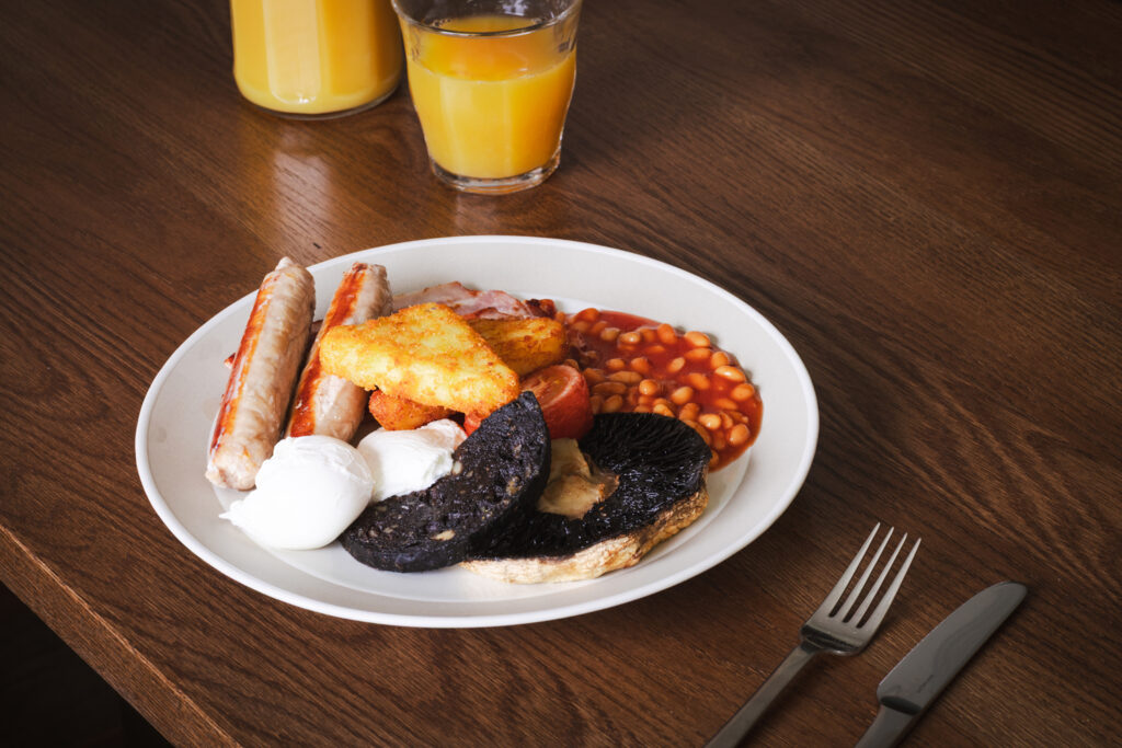 Full English Breakfast with orange juice and knife and fork