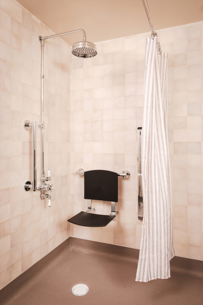 Barrier-free shower with grab bars and fold-down shower seat