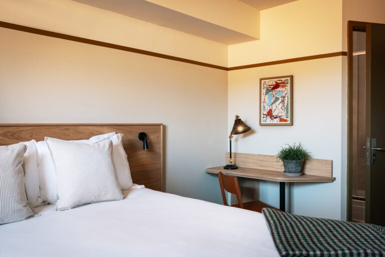 Double bed with desk, lamp and artwork