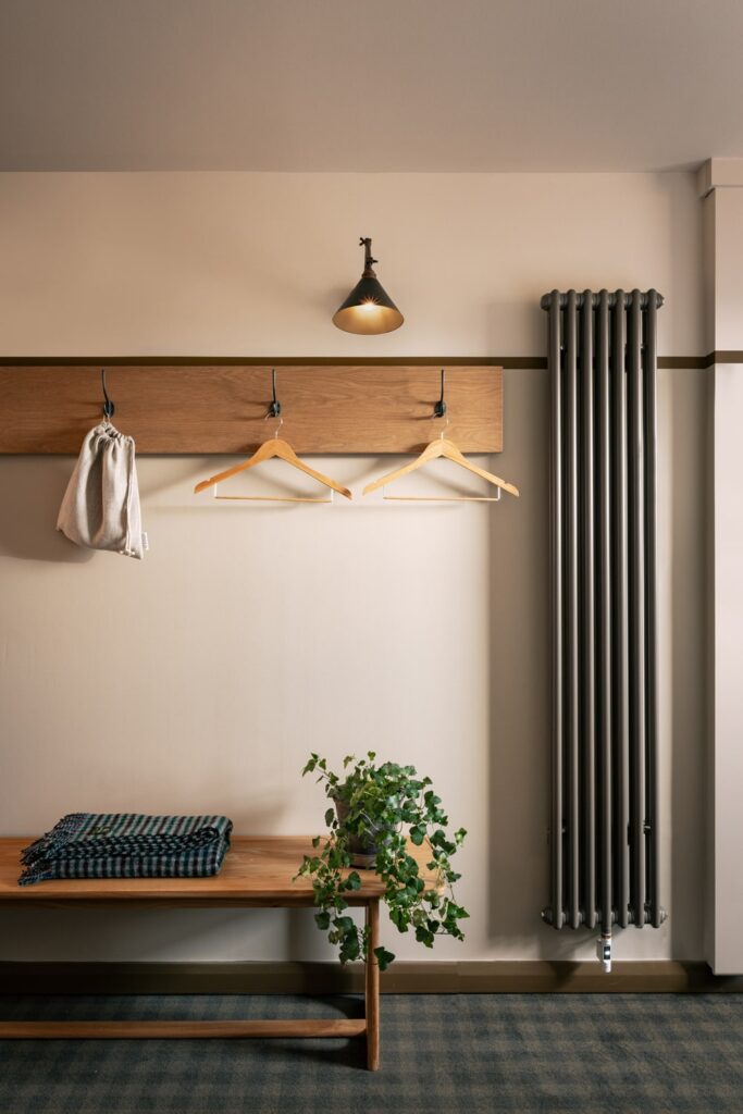 two coat hangers, a blanker and a plant on a bench